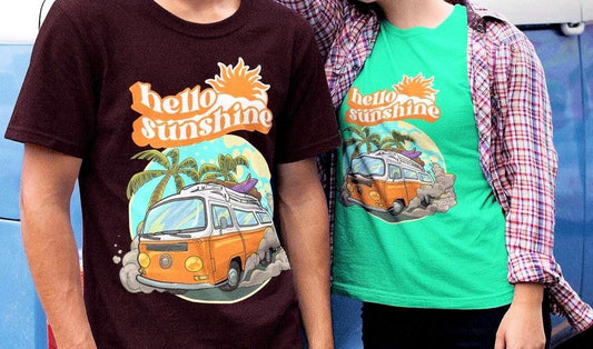 Two people wear retro summer t-shirts with a vintage orange van, surfboard, palm trees, and “hello sunshine” text. One wears brown, the other teal with plaid. Perfect for beach lovers, 70s style fans, unisex summer outfits, or matching couple looks.